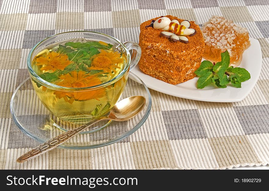 Herbal tea and cake on textile mat