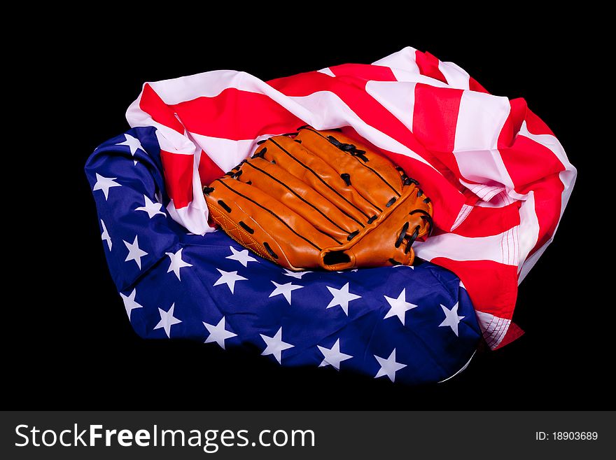 A baseball glove resting on an American flag. American supports baseball. A baseball glove resting on an American flag. American supports baseball.