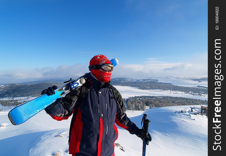 Skier looks into the distance on a mountain top. Skier looks into the distance on a mountain top