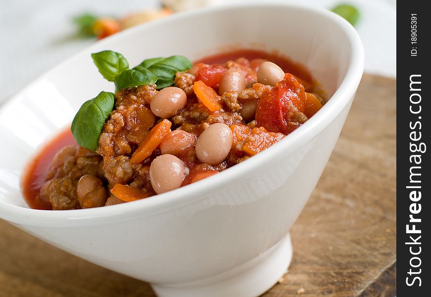 A bowl of chilli with bean and minced meat. Soft focus, shallow depth of field. A bowl of chilli with bean and minced meat. Soft focus, shallow depth of field.
