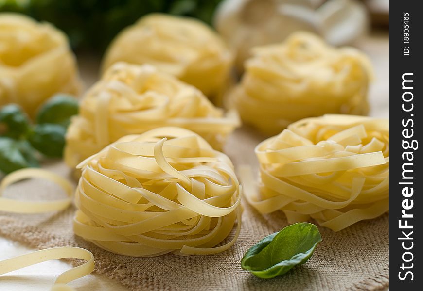 Pasta ingredients; fresh tagliatelle, garlic,basil 
Selective focus