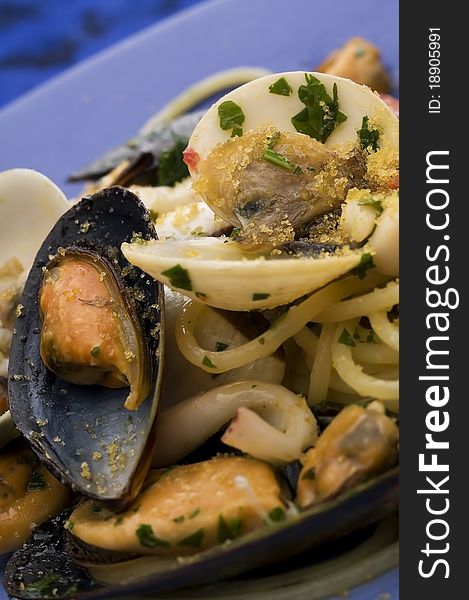 Spaghetti with seafood on blue dish