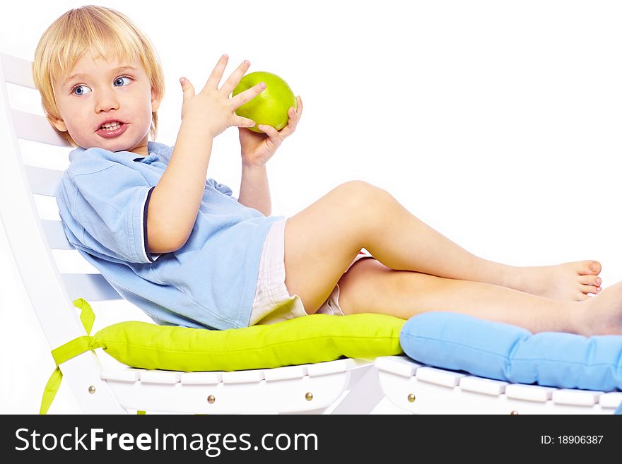 Little boy relaxing on chair with apple isolated over white. Little boy relaxing on chair with apple isolated over white