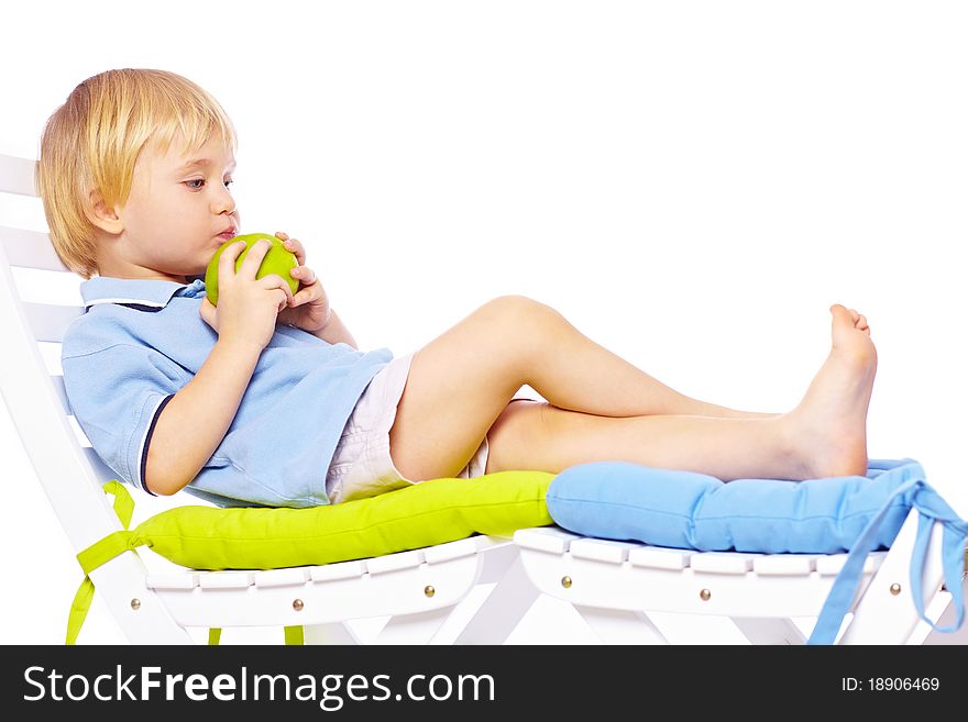 Little boy relaxing on chair with apple isolated over white back. Little boy relaxing on chair with apple isolated over white back