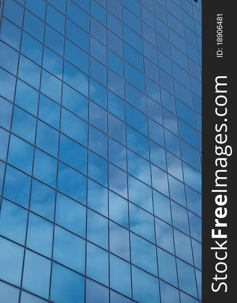 Architectural glass feature reflects cloudscape and blue sky. Architectural glass feature reflects cloudscape and blue sky.