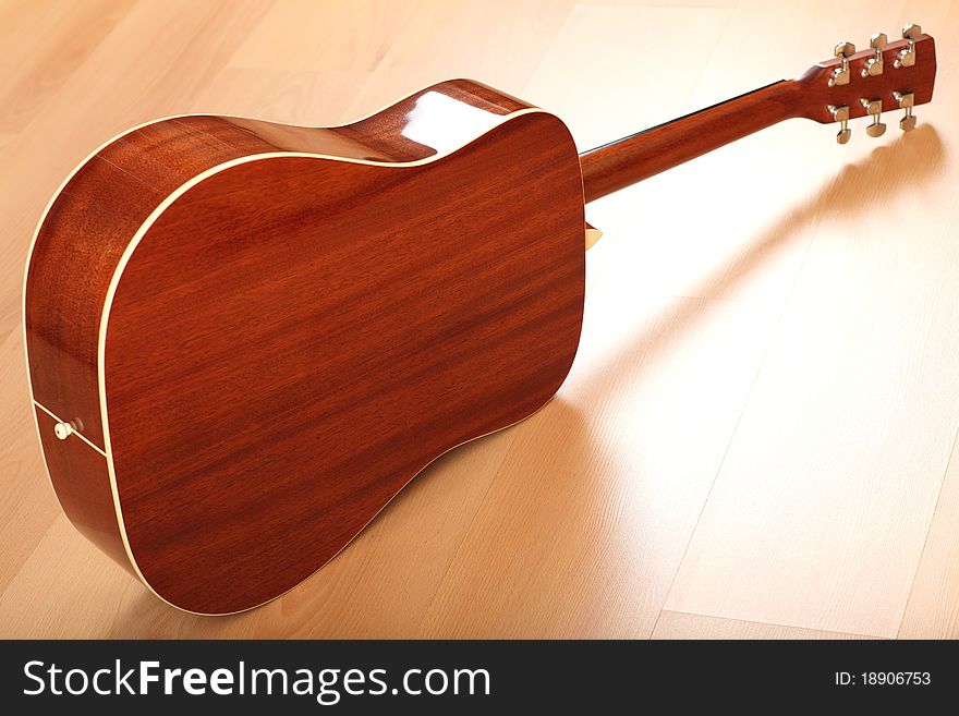 Brown guitar on neutral background; back view