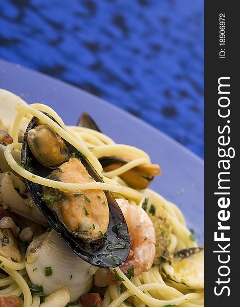 Spaghetti with seafood on blue dish