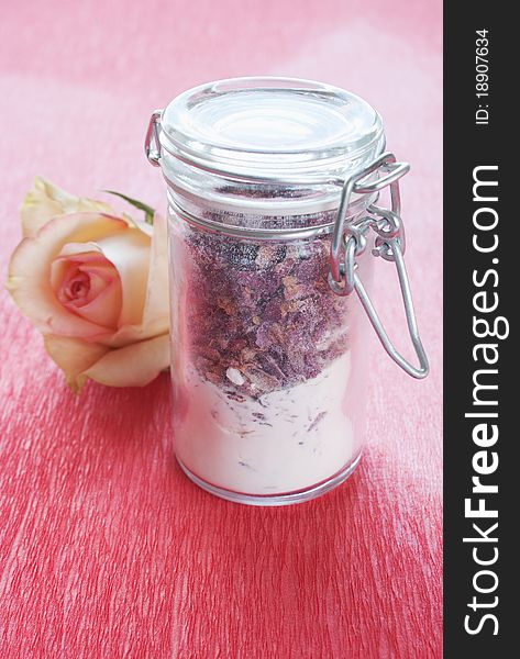 Dried rose petals in a jar with rose