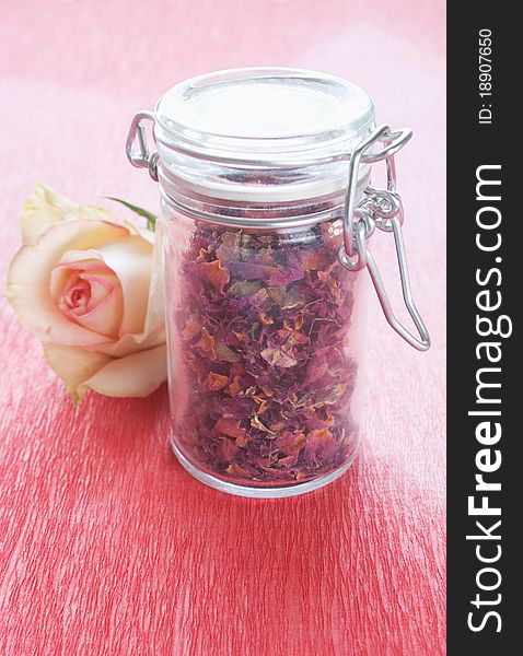Dried rose petals in a jar with rose