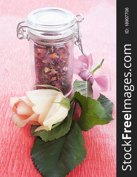 Dried rose petals in a jar with rose