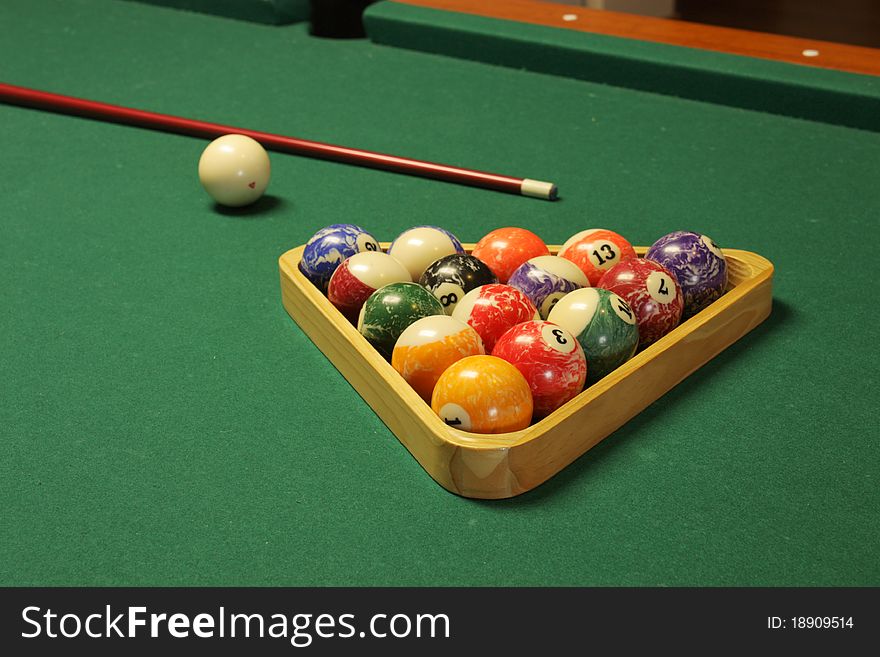 Pool stick, balls, and table used to play pool