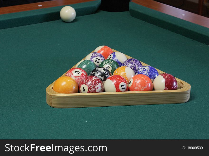 Arranged the balls in a triangular shape to start a game of pool. Arranged the balls in a triangular shape to start a game of pool