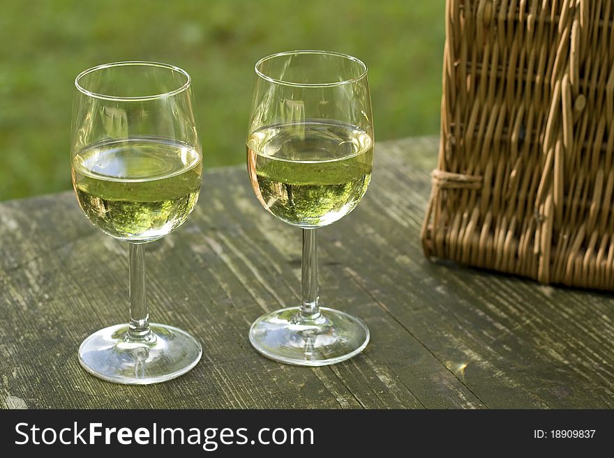 Wineglass on Picnic table with basket. Wineglass on Picnic table with basket