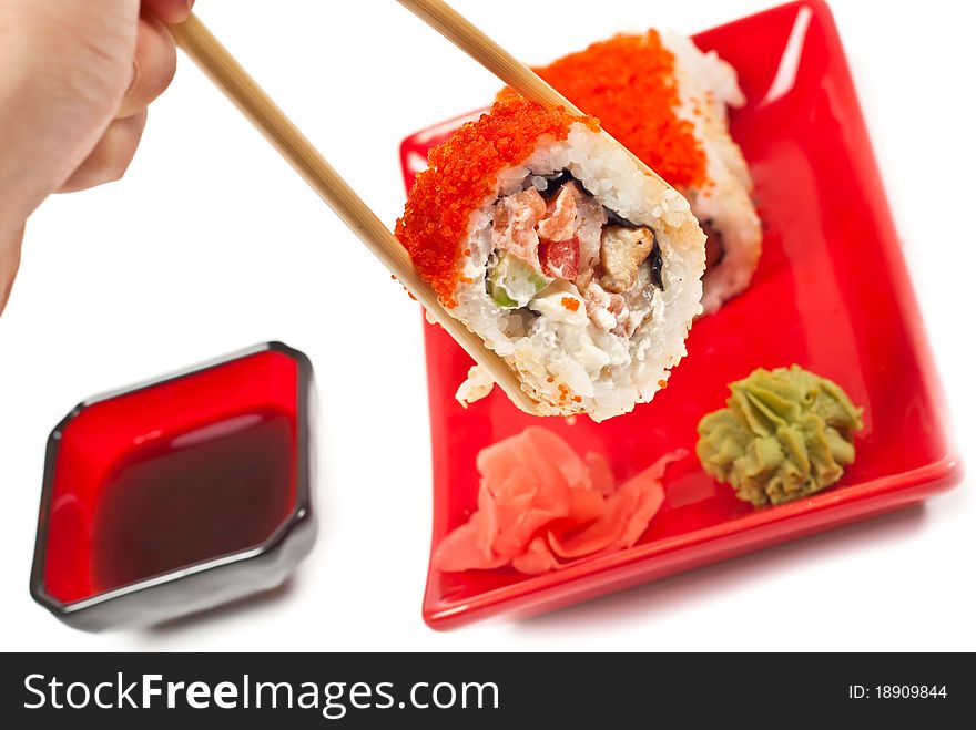 Men's hand holding sushi served on a plate. White background