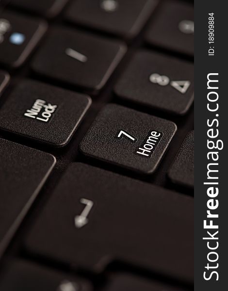 Black notebook keyboard with focus on home key, closeup. Black notebook keyboard with focus on home key, closeup
