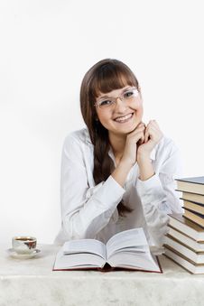 Beautiful Smiling Girl Reading A Book At The Table Stock Photography