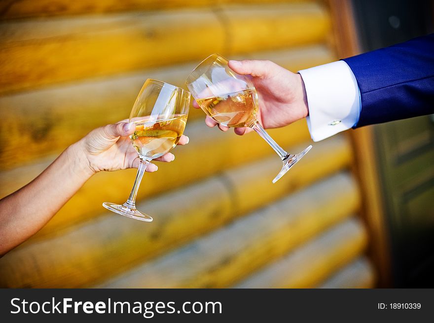 Glasses of the sparkling groom in hands and brides