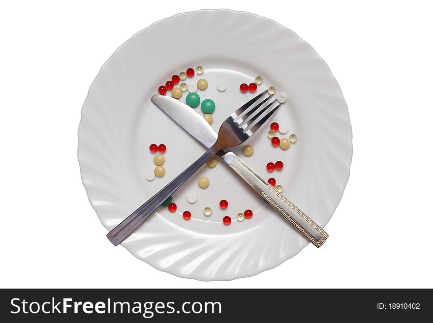 Vitamin photo on a white plate, the fork and a knife. Vitamin photo on a white plate, the fork and a knife