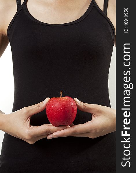 A woman with black tank top holding an apple. A woman with black tank top holding an apple.