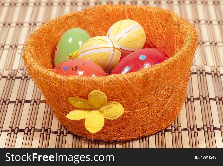 Colorful painted easter eggs in orange basket