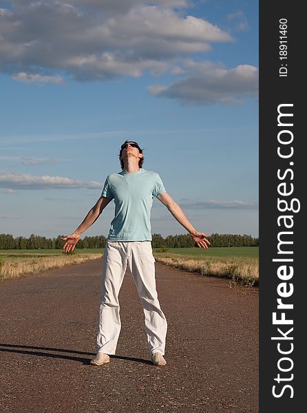Young man looking up in the sky at open road. Young man looking up in the sky at open road