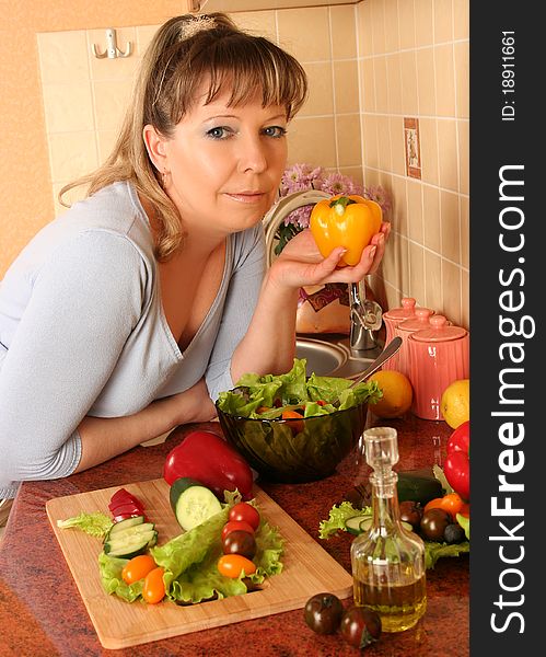 Adult woman preparing salad at domestic kitchen. Adult woman preparing salad at domestic kitchen