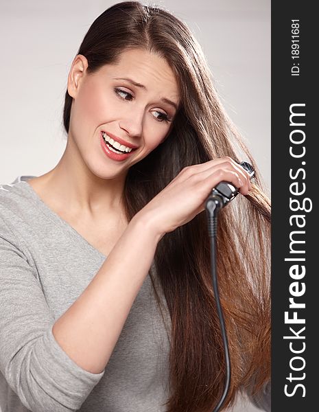 Portrait of beautiful woman with straightener on natural background. Portrait of beautiful woman with straightener on natural background