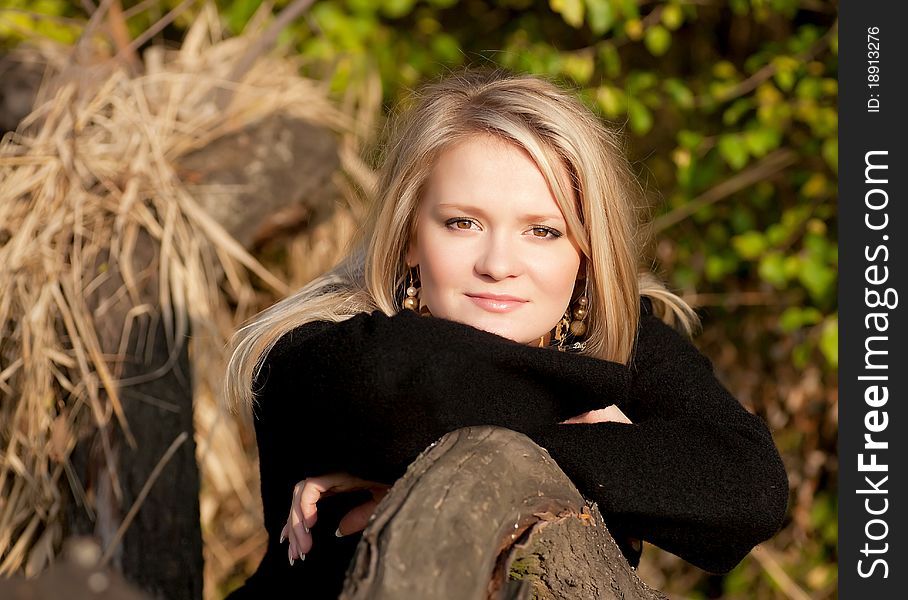 Autumn portrait of a blonde girl who looking at the frame