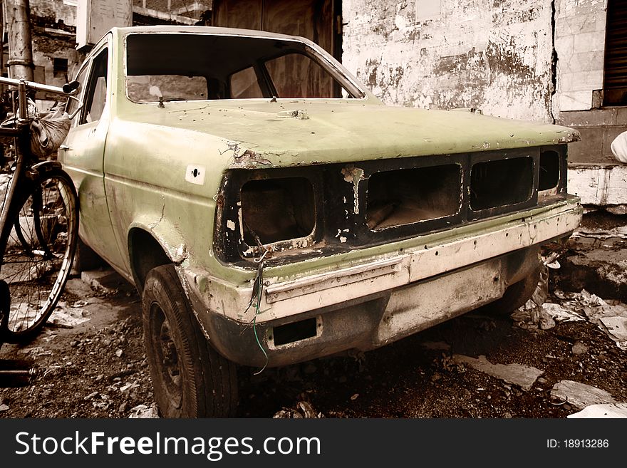 Rustic car in junk yard in sepia color tone