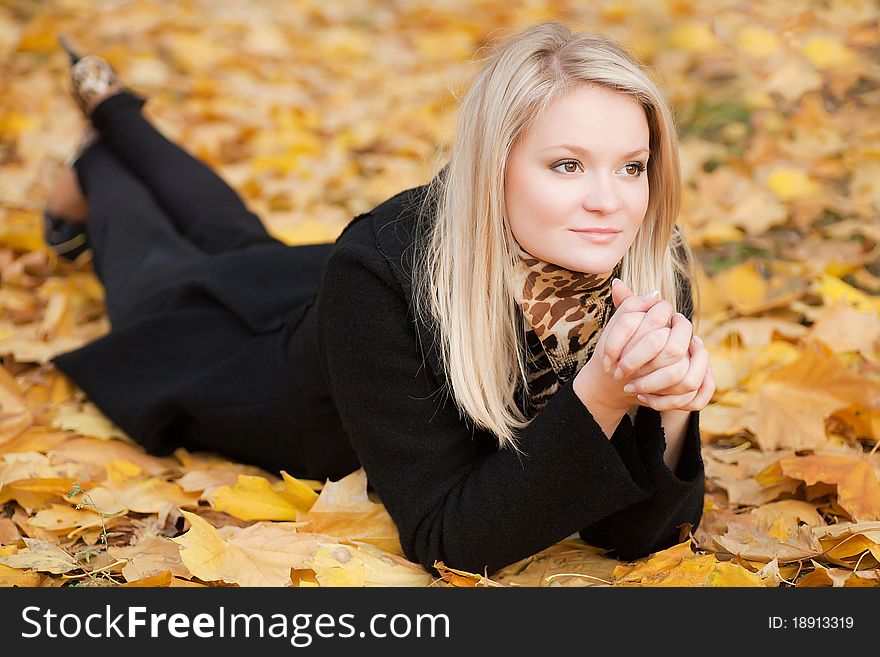 The girl lies on the yellow leaves. The girl lies on the yellow leaves