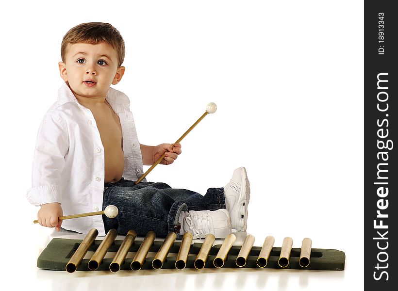 An adorable baby boy playing golden xylophone-style pipes. Isolated on white. An adorable baby boy playing golden xylophone-style pipes. Isolated on white.