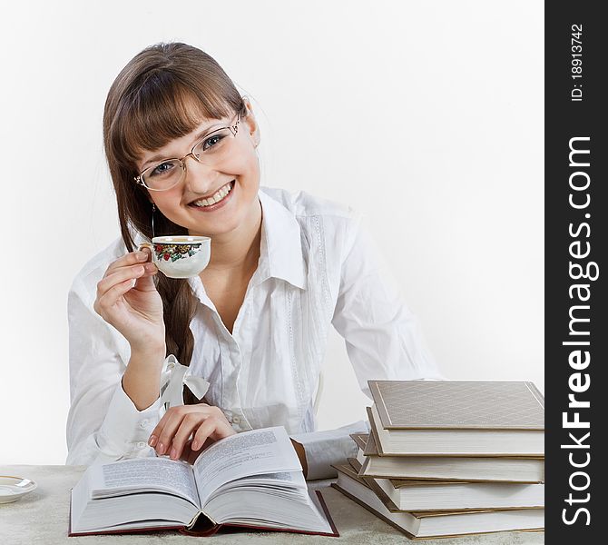 Smiling girl reading a books and drinking coffee