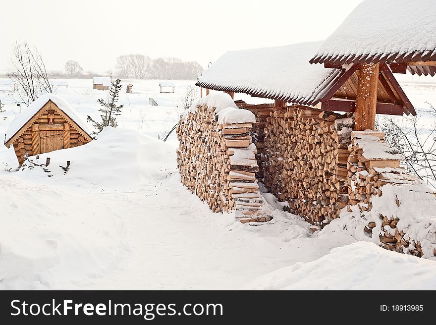 The photo shows a firewood in the snow. The photo shows a firewood in the snow