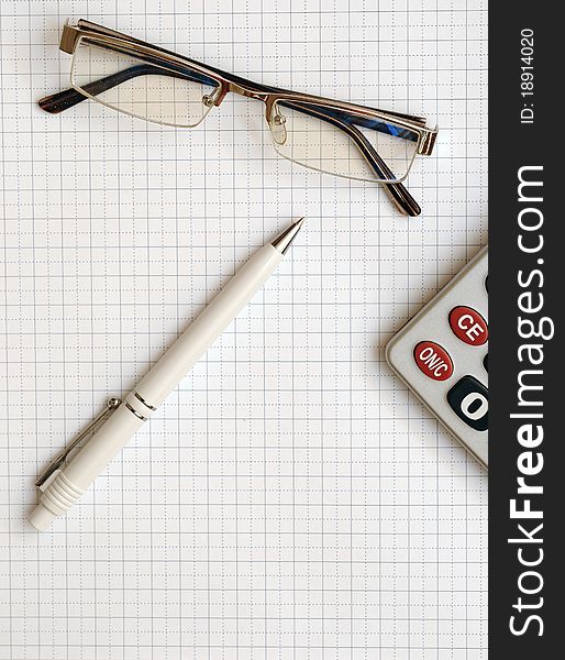 Pen, eyeglass, and calculator on the working paper