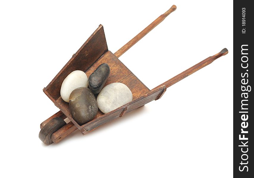 Miniature model of the wheelbarrow with stones on white