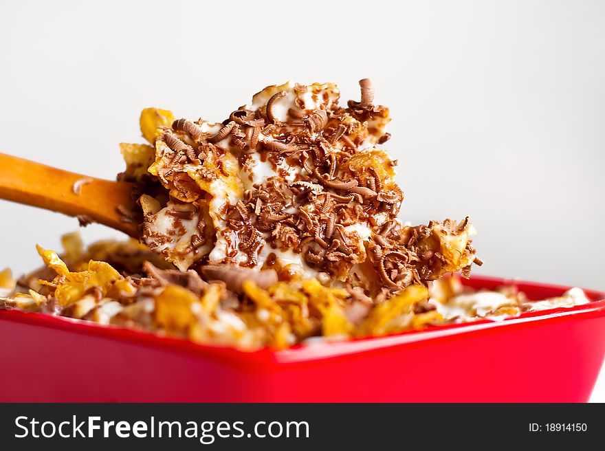 Fast and healthy breakfast. Corn flakes with milk and grated chocolate. Wooden spoon is for natural taste of this sweet food. Fast and healthy breakfast. Corn flakes with milk and grated chocolate. Wooden spoon is for natural taste of this sweet food.