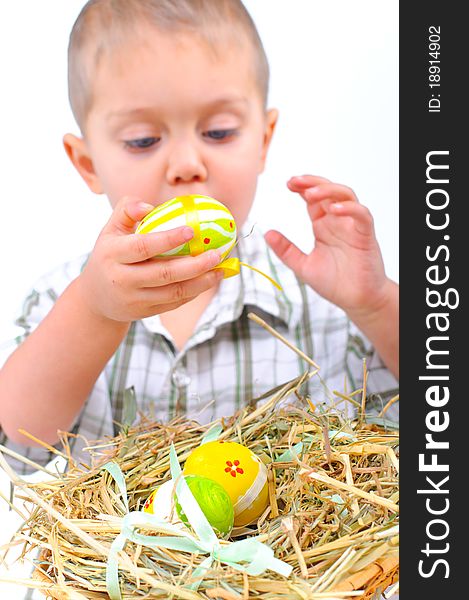 Little boy playing with easter eggs in basket. Focus on the eggs. Little boy playing with easter eggs in basket. Focus on the eggs.