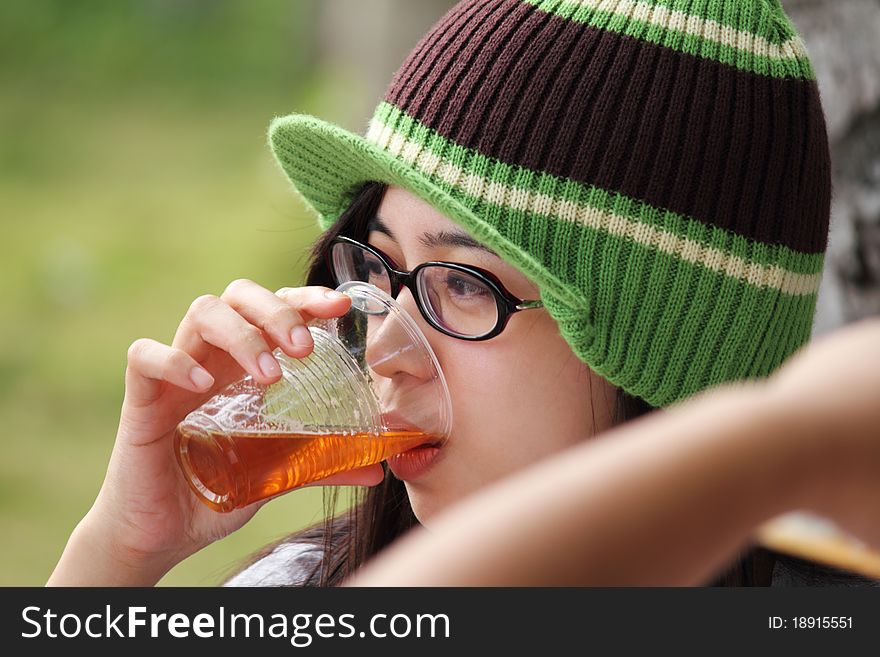 Young lady drinking beer on a plastic cup. Young lady drinking beer on a plastic cup