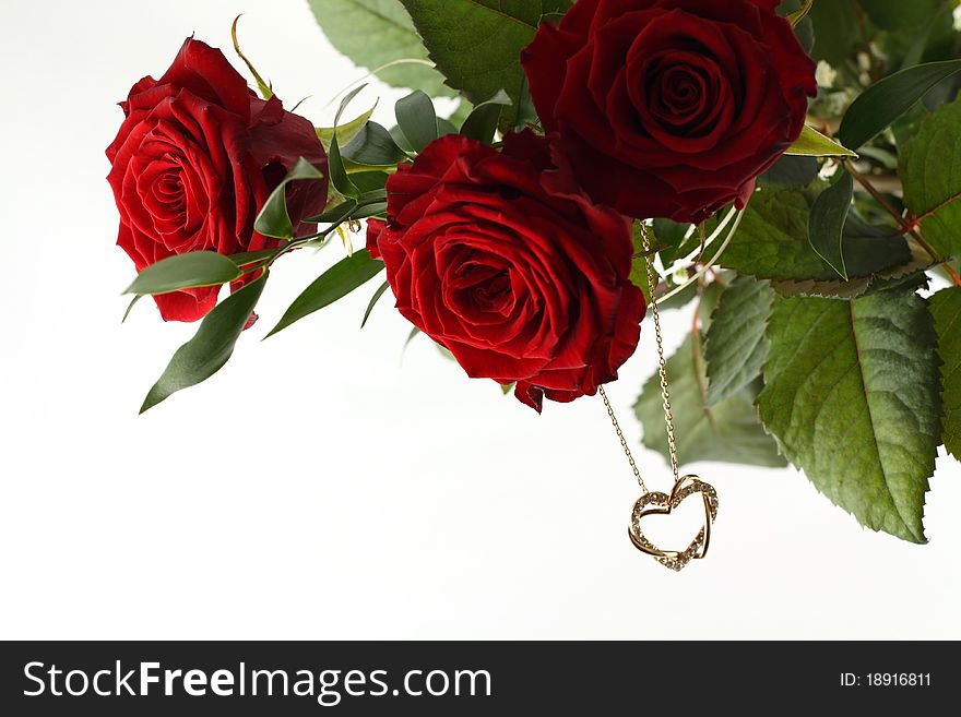 Bouquet of three red roses and gold heart on white background. Bouquet of three red roses and gold heart on white background.