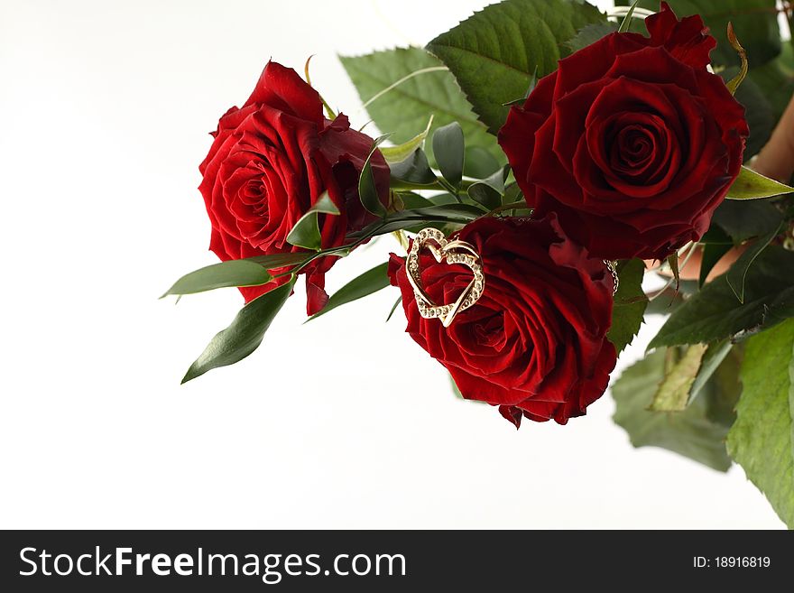 Bouquet of three red roses and gold heart on white background. Bouquet of three red roses and gold heart on white background.