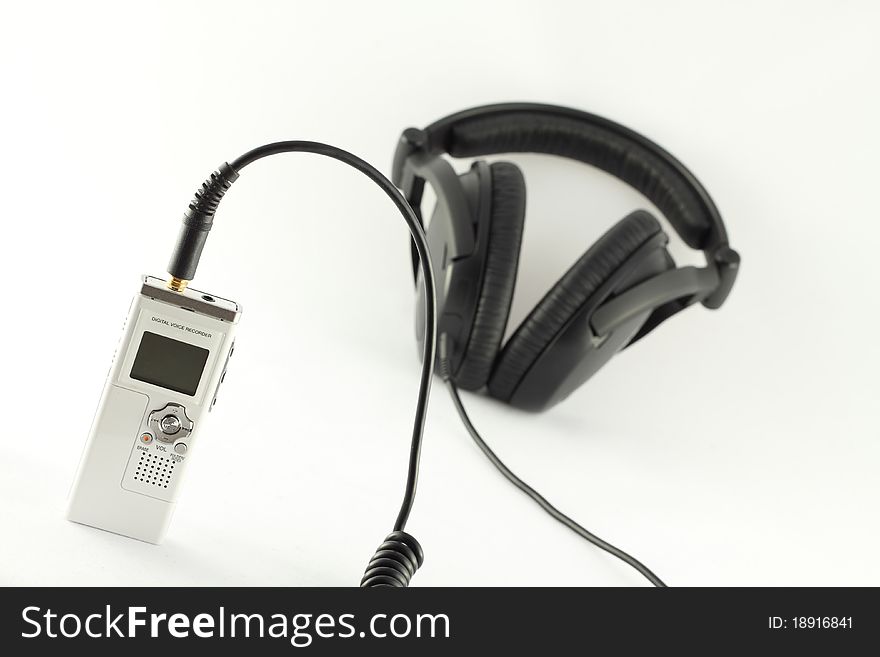 White digital voice recorder and black headphone on white background. White digital voice recorder and black headphone on white background.