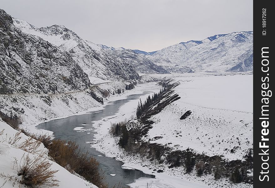 Thawing river in the dark surrounded by mountains. Thawing river in the dark surrounded by mountains