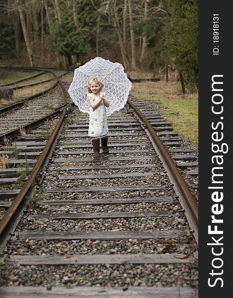 Young girl running towards the camera while holding an umbrella. Young girl running towards the camera while holding an umbrella