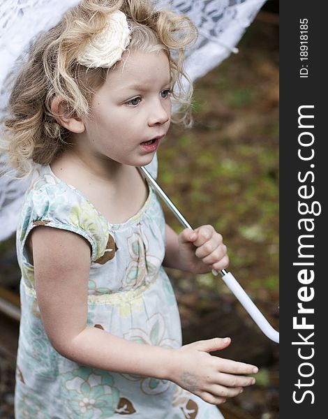 Beautiful young girl holding an umbrella while looking off to the side. Beautiful young girl holding an umbrella while looking off to the side.