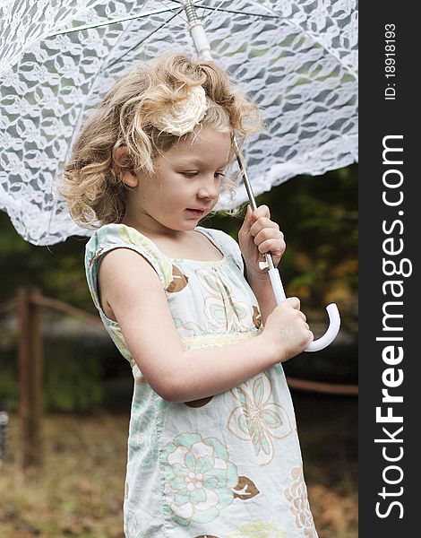 Beautiful young girl holding an umbrella while looking off to the side. Beautiful young girl holding an umbrella while looking off to the side.