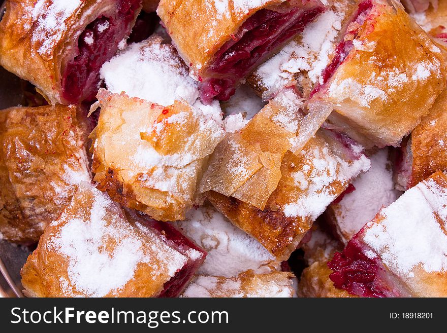 Cherry pie slices with fine sugar on top. This is traditional Balkan pie with cherry fruit. It is made differently from American pie.