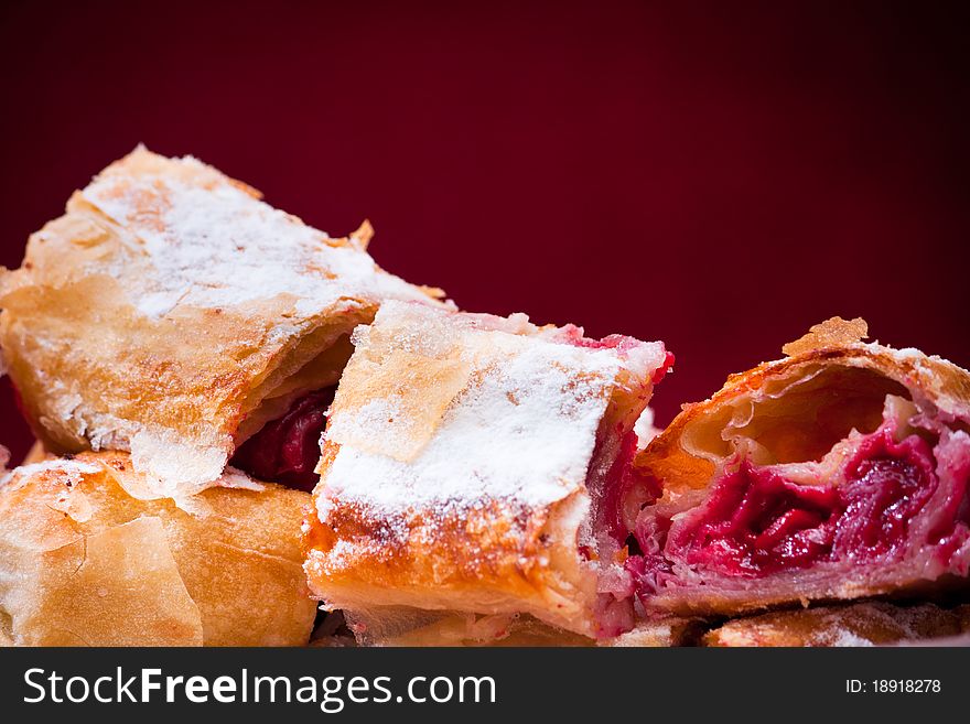 Cherry pie slices with fine sugar on top. This is traditional Balkan pie with cherry fruit. It is made differently from American pie.