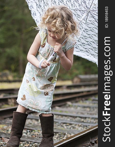 Beautiful young girl holding an umbrella while looking off to the side. Beautiful young girl holding an umbrella while looking off to the side.