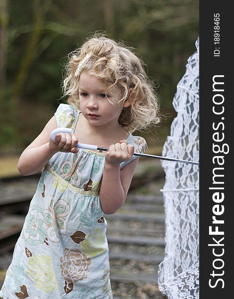 Beautiful young girl holding an umbrella while looking off to the side. Beautiful young girl holding an umbrella while looking off to the side.