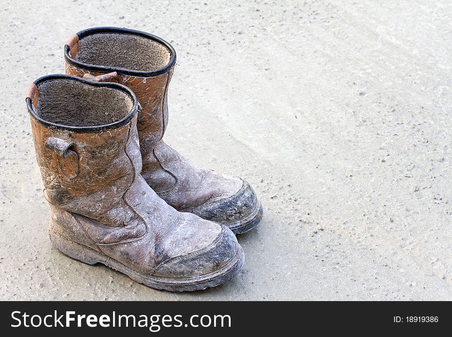 Old brown work boots on concrete